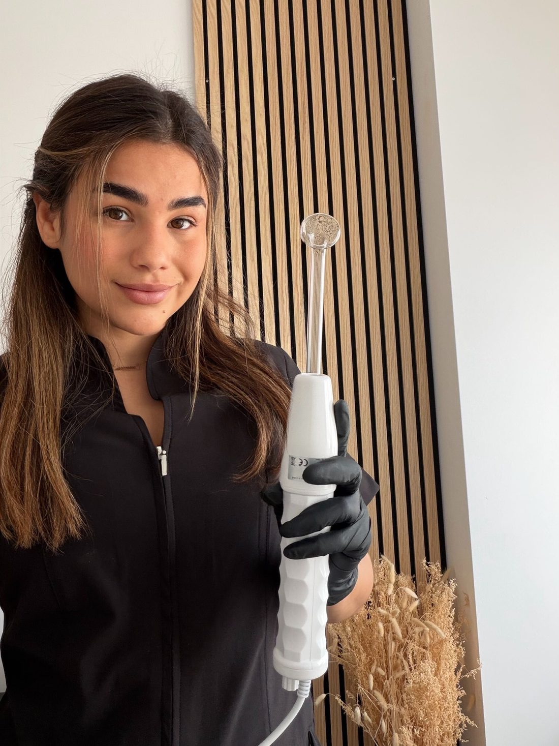 Yesica Lozada en su cabina, con un cabezal de aparatología en la mano